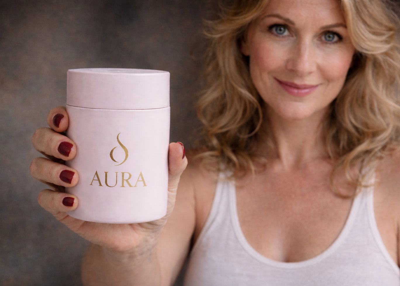 Woman holding a pink container labeled 'Aura' against a neutral background